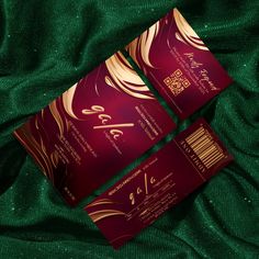 two red and gold business cards on green fabric