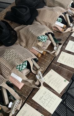 several hats are lined up next to each other on a table with paper tags attached to them