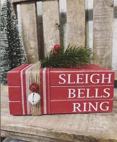 a red box sitting on top of a wooden table with a christmas decoration in it