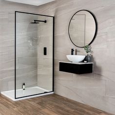 a bathroom with a sink, mirror and stand up shower