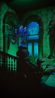 a dark room with green lighting and an iron railing