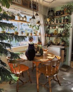 a black cat sitting on top of a wooden table