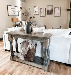 a living room with a couch, table and pictures hanging on the wall above it