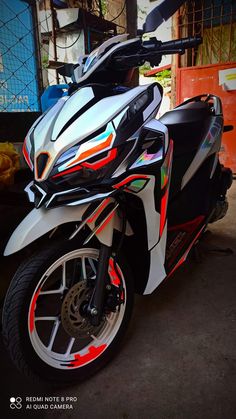 a white and black motorcycle parked in front of a building