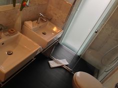 a bathroom with two sinks, a toilet and a shower stall is shown in this image