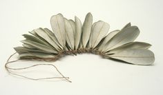 a group of white leaves sitting on top of a white table next to a string