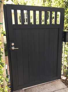 a black wooden gate in front of a house