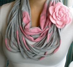 a woman wearing a gray and pink scarf with a flower on the end of it