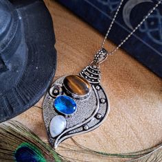 Add some enchanting witchy vibes to your jewelry collection with this stunning  magic lantern 925 Silver pendant necklace. Handcrafted with love, this necklace features beautiful tigers eye, moonstone and blue topaz gemstones . This unique piece of witchy jewelry will bring forth positive energy and a witchy magical style to any outfit. Embrace your inner witch and channel your mystic powers with this captivating necklace.  These unusual pieces are lovingly handmade using hand picked natural sto Necklace Magic, Blue Topaz Pendant Necklace, Inner Witch, Magic Lantern, Blue Topaz Pendant, Witchy Jewelry, Topaz Pendant, Jewelry For Men, Witchy Vibes