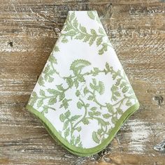 a green and white napkin on top of a wooden table