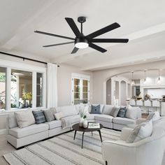 a living room filled with furniture and a ceiling fan