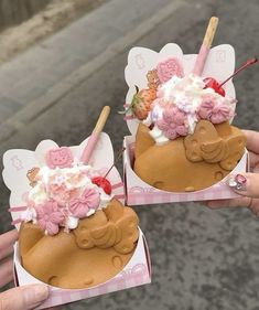 two people holding up small cakes with flowers on them in the shape of animals and bears