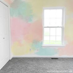 an empty room painted in pastel colors with a window on the far wall and carpeted floor