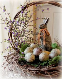 a basket filled with eggs sitting on top of a table next to a bunny figurine