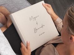 a woman is holding up a book with writing on it