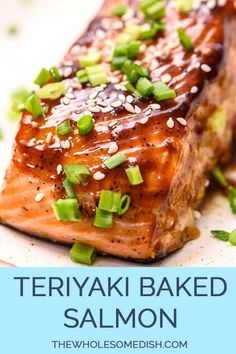 a piece of salmon with sesame seeds and green onions on top, sitting on a white plate