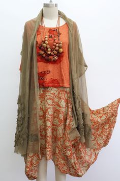 a mannequin wearing an orange top and skirt with beads on it's neck