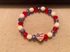 a red, white and blue beaded bracelet with an american flag heart on it