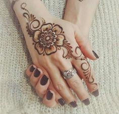 two hands with henna tattoos on them