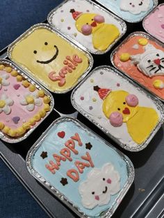 six decorated birthday cakes sitting on top of each other in tins with the words happy day written on them