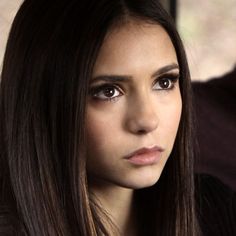 a close up of a person with long hair and brown eye shadow on her face