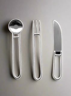 there are three forks and two spoons next to each other