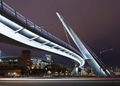 an illuminated bridge over a city street at night