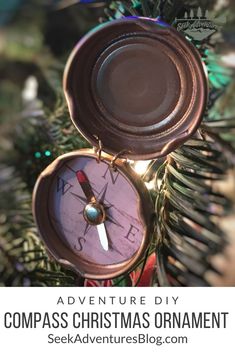 a compass ornament hanging from a christmas tree with text overlay reading adventure diy compass christmas ornament