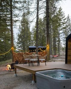 a hot tub sitting on top of a wooden deck next to a table and chairs