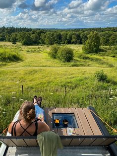 two people sitting at a picnic table in the middle of a field