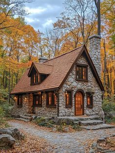 a small stone house surrounded by trees and leaves