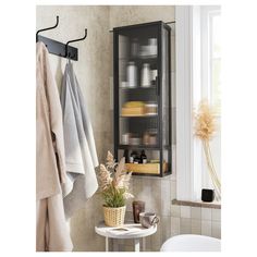 a bathroom with towels hanging on the wall and a towel rack in front of it