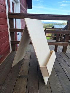 an upside down shelf sitting on top of a wooden deck next to a red building