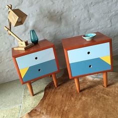 two colorful nightstands sitting next to each other on top of a cow skin rug