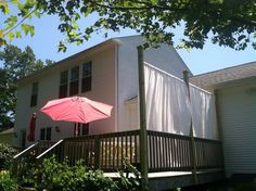 an umbrella is sitting on the back deck of a house