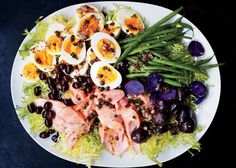 a white plate topped with salad and hard boiled eggs