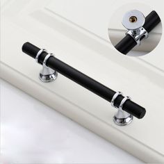 two black handles on a white door with chrome knobs and an image of the handle