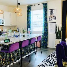 a kitchen island with purple chairs in front of it