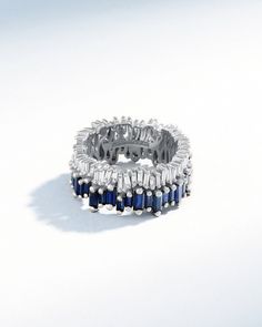 Crafted in 18-karat gold, This eternity band is a breathtaking display of precision and luxury. It features 4 carats of stunning dark blue sapphire baguettes, expertly set in the Suzanne's signature uneven design. The sapphires and diamonds are a mix of differently sized baguettes, adding depth and dimension to the design. Details 18k white gold 4.00 carats of dark blue sapphire baguettes 0.88 carats of baguette white diamonds 11mm width Ref: BAR773 Luxury Sapphire Ring With Baguette Diamonds, Modern Blue Rings With Baguette Diamonds, Modern Sapphire Baguette Cut Ring, Luxury Sapphire Baguette Cut Ring, Luxury Silver-tone Lab-created Sapphire Ring, Luxury Silver Lab-created Sapphire Ring, White Gold Sapphire Baguette Cut Jewelry, White Gold Sapphire Jewelry With Baguette Cut, White Gold Sapphire Jewelry In Baguette Cut