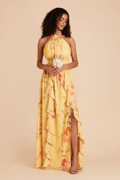 a woman wearing a yellow dress with flowers on it