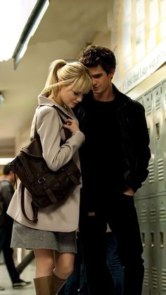 a young man and woman standing next to each other in front of lockers at an airport