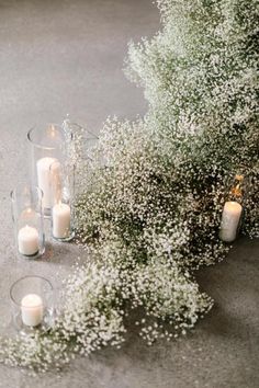 candles and baby's breath flowers on the ground