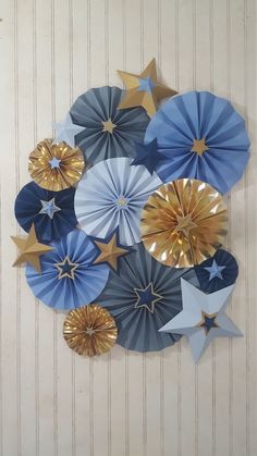 several blue and gold paper stars hanging on the wall in front of a white door