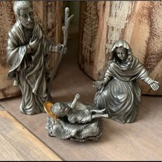 two statues of jesus and mary are on the floor next to each other, one is laying down