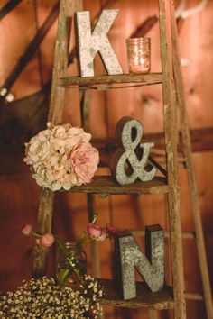 a wooden ladder with letters and flowers on it