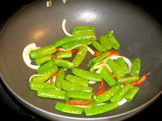 green peppers and onions cooking in a wok