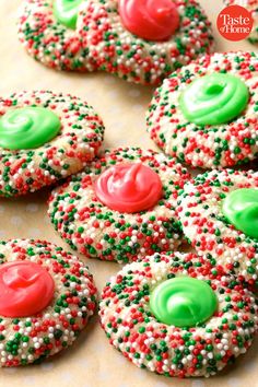 christmas sprinkle cookies with green and red frosting on top are arranged in rows