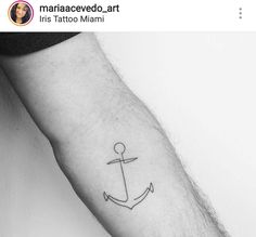 a small anchor tattoo on the arm