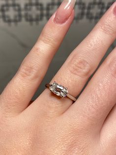 a close up of a person's hand with a ring on their finger and an oval shaped diamond in the middle