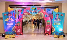 an entrance to a building decorated in bright colors with people walking down the hall behind it